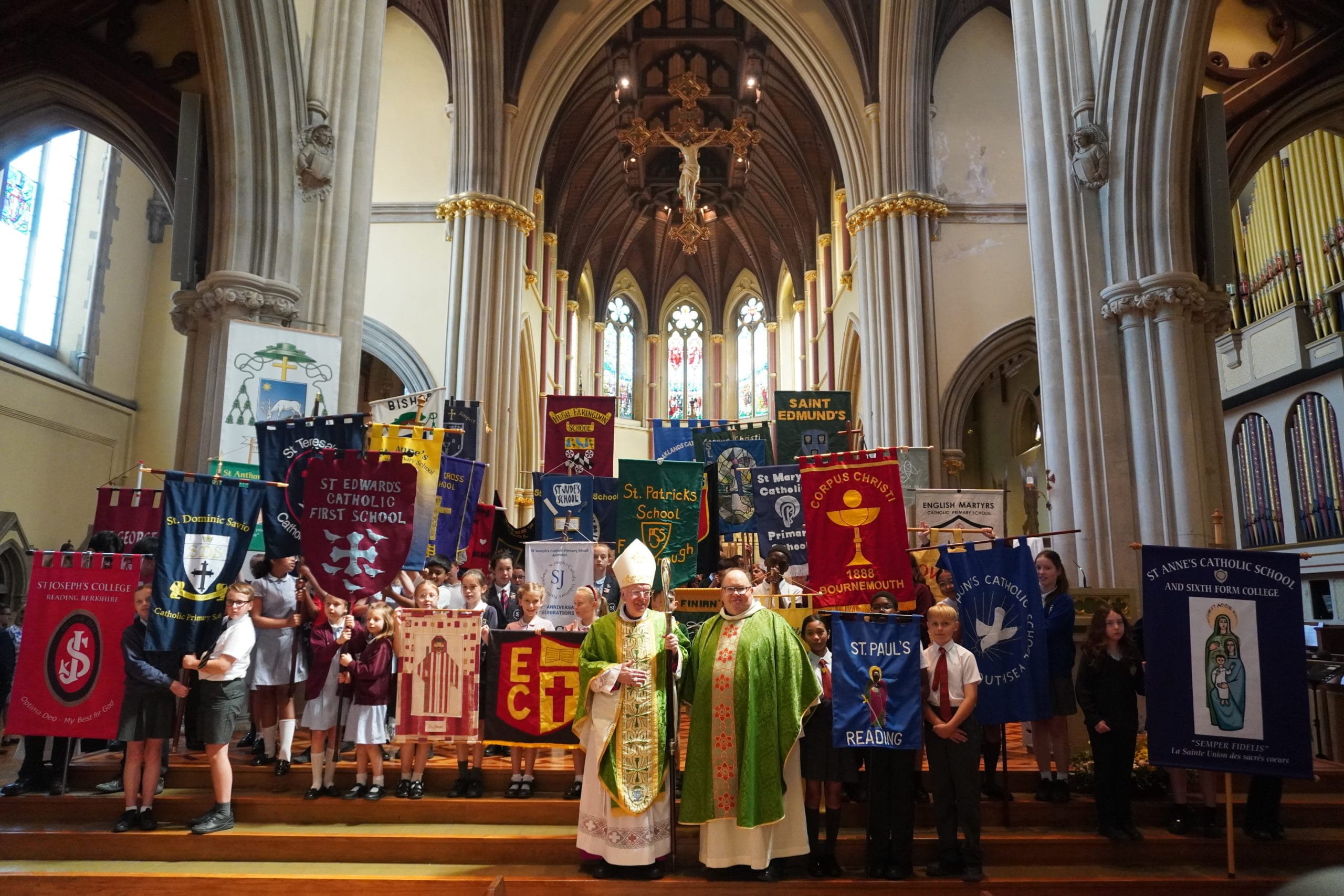 Annual School’s Mass 2025 A picture showing students with their school's flags and The Bishop of Portsmouth together with the Canon for Education.