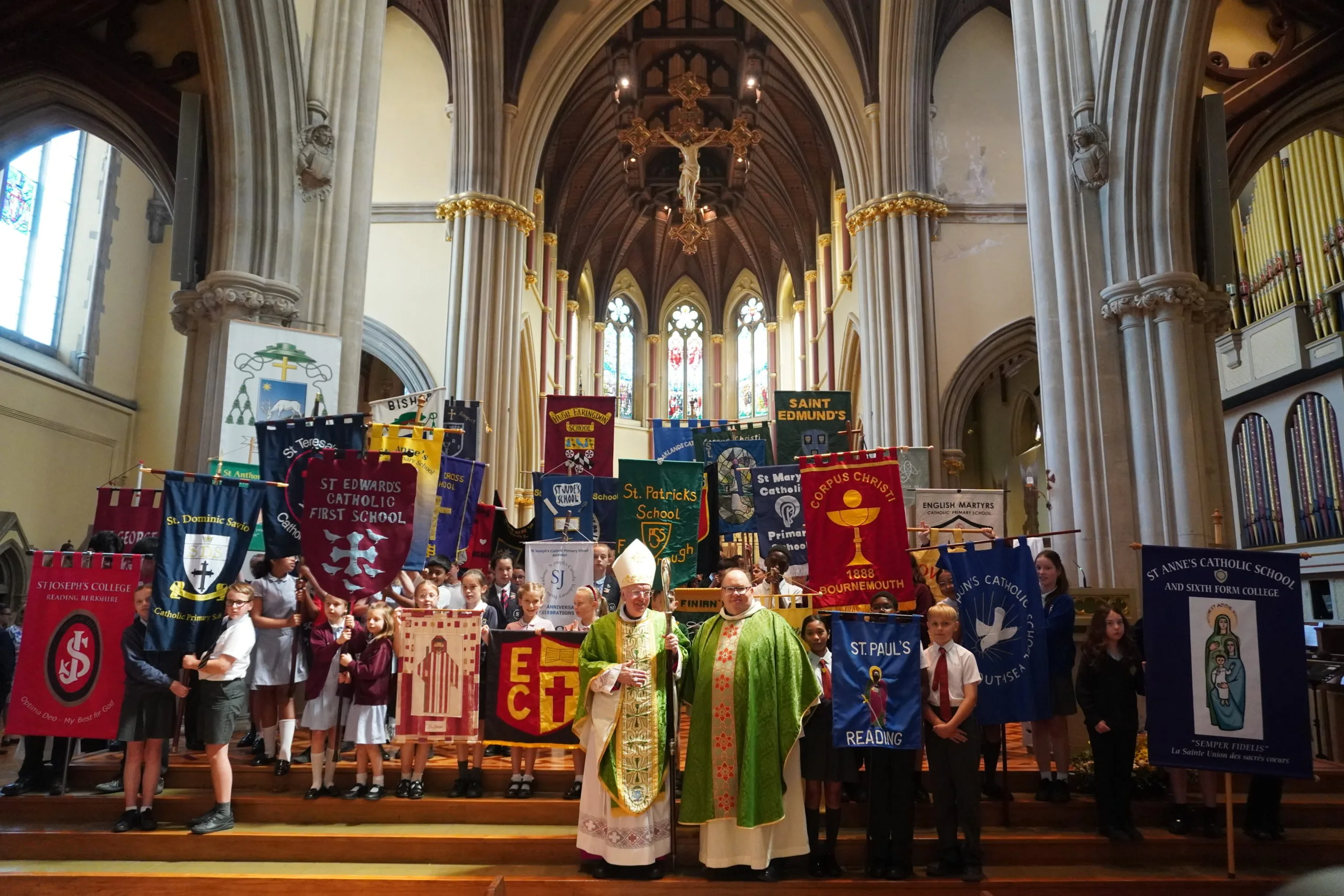 Annual School’s Mass 2025 A picture showing students with their school's flags and The Bishop of Portsmouth together with the Canon for Education.
