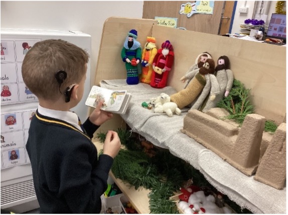 St Judes – Hearing Impaired and Bible Figures A pupil with a hearing aid looking at biblical figures and a book