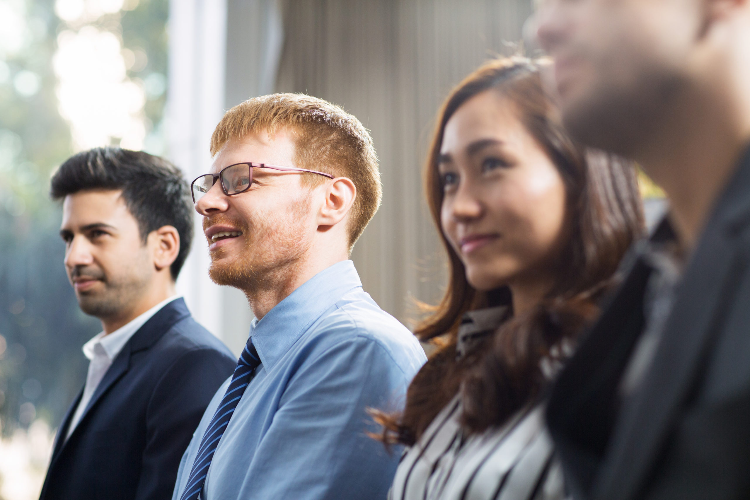 Business people listening to speaker and smiling