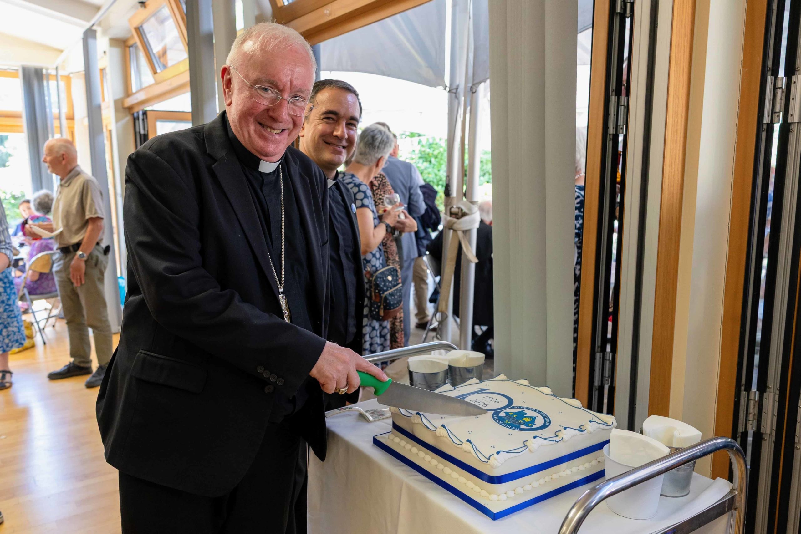 Bishop Philip cutting cake Bishop Philip cutting some cake for the 100th anniversary of St Peter's Winchester
